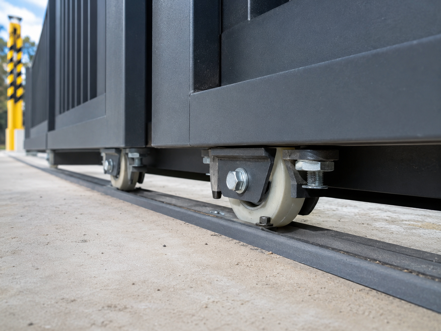 Heavy-duty sliding gate supported by plastic-coated bearing rollers on a track