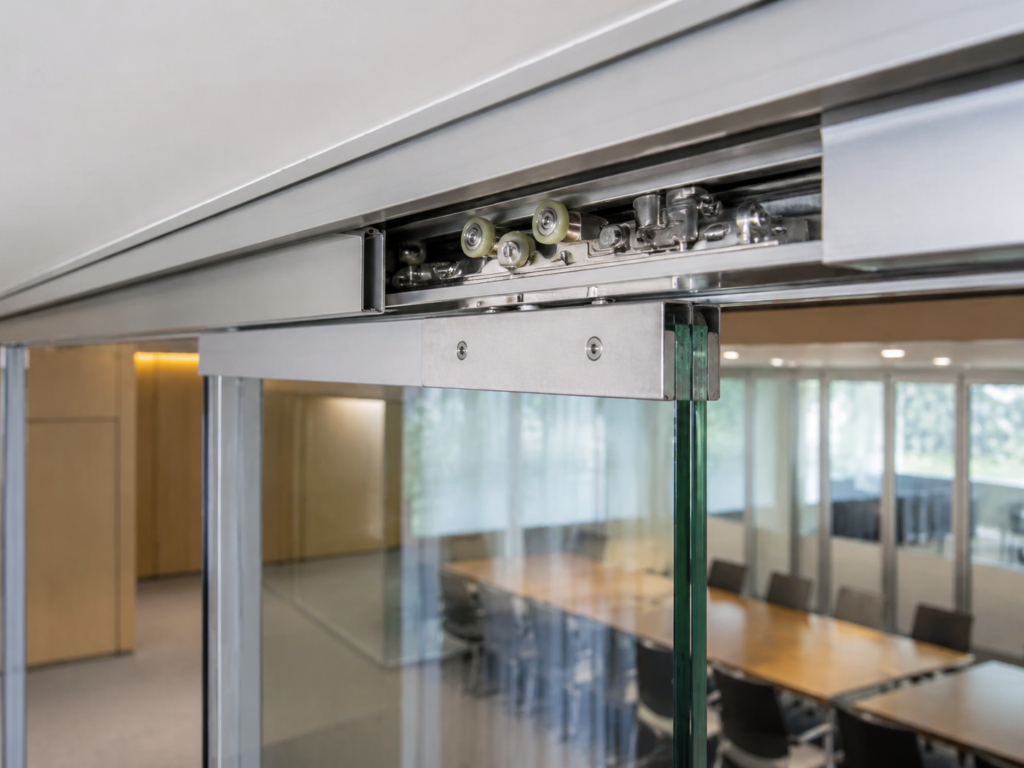 Roller assemblies installed in a three-panel telescopic sliding door system